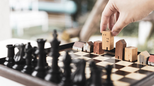Chess board with black chess pieces and white houses