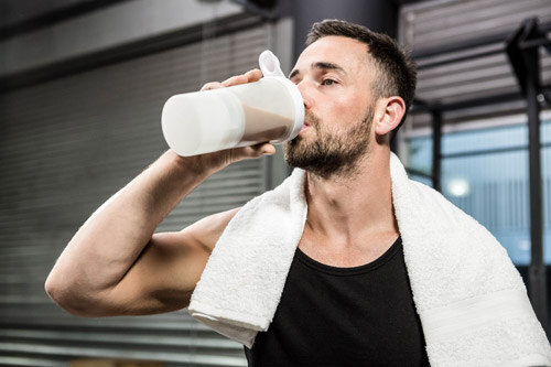 Man drinking a protein shake in the gym